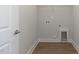 Bright laundry room with wood-look floors, washer hookups, and crisp white trim at 210 Cason Dr, Gibsonville, NC 27249