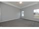 Carpeted main bedroom with a ceiling fan, tray ceiling, neutral paint and bright natural light at 210 Cason Dr, Gibsonville, NC 27249