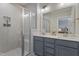 Bright bathroom features a double sink vanity with quartz countertop, large mirror, and glass enclosed tiled shower at 228 Sacred Fire Rd, Louisburg, NC 27549