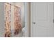 Bathroom with shower and flowered shower curtain, toilet, and white door at 228 Sacred Fire Rd, Louisburg, NC 27549