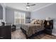 Well-lit bedroom featuring a ceiling fan, hardwood floors, and a large window at 228 Sacred Fire Rd, Louisburg, NC 27549