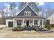 Charming two-story home featuring a welcoming front porch with seating and manicured landscaping at 228 Sacred Fire Rd, Louisburg, NC 27549