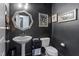 Stylish powder room with dark walls, unique mirror, and pedestal sink at 228 Sacred Fire Rd, Louisburg, NC 27549