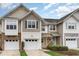 Charming townhome featuring a two-car garage and varied exterior finishes of stone, siding, and wood at 2314 Wispy Green Ln, Raleigh, NC 27614