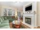 Welcoming living room features a fireplace, green sofa and large windows for ample natural light at 2314 Wispy Green Ln, Raleigh, NC 27614