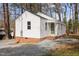Charming bungalow-style home with white siding and a brick foundation in a wooded neighborhood at 2506 Dominion St, Durham, NC 27704