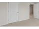 Neutral carpeted bedroom with white trim, door, and glimpse into a hallway at 269 Umstead St, Sanford, NC 27330