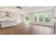 Open-concept living room featuring hardwood floors, a fireplace, and a kitchen view with sliding doors to backyard at 269 Umstead St, Sanford, NC 27330