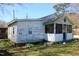 Side exterior of the house with white siding and a screened porch, highlighting the classic design features at 2984 Ashe Ave, Dunn, NC 28334
