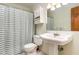 Traditional bathroom featuring a shower with striped curtain, pedestal sink and mirrored vanity at 3101 Rutledge Ct, Raleigh, NC 27613