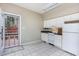 Functional kitchen equipped with white appliances, tiled flooring, and access to an outdoor patio at 3101 Rutledge Ct, Raleigh, NC 27613