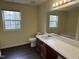 Well-lit bathroom featuring a white sink, dark wood cabinets, and a large mirror at 316 Arbor Greene Dr, Garner, NC 27529