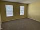 Bedroom with neutral carpet, light-colored walls, and two windows with blinds at 316 Arbor Greene Dr, Garner, NC 27529