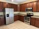 Kitchen with stainless steel appliances, tile floor, and wooden cabinets at 316 Arbor Greene Dr, Garner, NC 27529