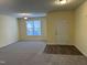 Open living area with neutral walls, plush carpeting, a bright window, and a door, offering lots of natural light at 316 Arbor Greene Dr, Garner, NC 27529