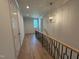 Hallway with wood flooring and modern lighting offers access to other rooms and stairway at 3405 Makers Circle, Raleigh, NC 27612