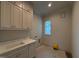 Laundry room featuring a sink, cabinets, countertops, and washer and dryer hookups at 3405 Makers Circle, Raleigh, NC 27612
