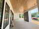 Covered patio features wood paneled ceiling, gray accent wall, and dark trimmed windows at 3405 Makers Circle, Raleigh, NC 27612