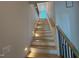 Bright stairway with hardwood steps and black metal railing leads to the upper levels of the home at 3405 Makers Circle, Raleigh, NC 27612