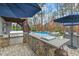 Backyard oasis featuring a stone-clad kitchen, seating area, and pool with a waterfall feature at 3548 Willow Green Dr, Apex, NC 27502