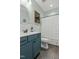 Cozy bathroom with blue vanity, decorative mirror and wood-look tile flooring at 3548 Willow Green Dr, Apex, NC 27502