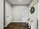 Entryway featuring white doors, wood-look floors, and a decorative bench with 'Home Sweet Home' pillow at 3548 Willow Green Dr, Apex, NC 27502