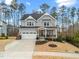 Charming two-story home with gray siding, white trim, a two-car garage and an American flag at 3548 Willow Green Dr, Apex, NC 27502