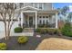 Inviting front porch with stone accents, rocking chairs, and manicured landscaping at 3548 Willow Green Dr, Apex, NC 27502