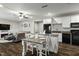 Cozy kitchen and living room with wood floors, ceiling fan, white cabinets and island with seating for two at 3548 Willow Green Dr, Apex, NC 27502