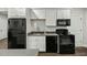 A well-equipped kitchen with black appliances, white cabinetry, and a subway tile backsplash at 3548 Willow Green Dr, Apex, NC 27502