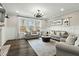 Bright living room featuring recessed lighting, dark wood floors, light gray furniture, and large windows with views of the surrounding trees at 3548 Willow Green Dr, Apex, NC 27502