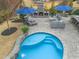 Aerial view of a backyard with a pool, waterfall, outdoor fireplace, kitchen, and seating at 3548 Willow Green Dr, Apex, NC 27502