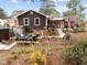 Backyard with brown siding, mature trees, yellow flowering bushes, and patio area at 412 N Cheatham St, Franklinton, NC 27525