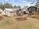 Spacious backyard featuring grass, storage sheds, mature trees, and blooming flowers at 412 N Cheatham St, Franklinton, NC 27525