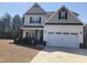 Two-story home with a two car garage, neutral siding and black shutters, landscaping, and a blue sky at 433 Falling Brook Dr, Kenly, NC 27542