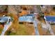 An aerial view of a brick house featuring a detached garage and large yard with a driveway at 4709 Stafford Dr, Durham, NC 27705