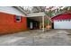View of the covered parking area and detached garage behind this brick home at 4709 Stafford Dr, Durham, NC 27705