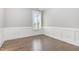 Bedroom with white wainscoting and hardwood floors with a bright window at 5072 Aspen Meadow St, Raleigh, NC 27616