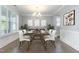 Elegant dining room featuring wainscoting, modern chandelier, plantation shutters, and plenty of natural light at 5072 Aspen Meadow St, Raleigh, NC 27616