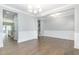 Open dining room with hardwood floors, wainscoting, and stylish lighting fixtures at 5072 Aspen Meadow St, Raleigh, NC 27616