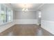 Bright dining room features hardwood floors, modern chandelier, plantation shutters, and wainscoting at 5072 Aspen Meadow St, Raleigh, NC 27616