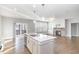 Kitchen island featuring a stainless steel sink, alongside a stone fireplace and sliding glass doors at 5072 Aspen Meadow St, Raleigh, NC 27616
