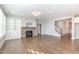 Spacious living room featuring a stone fireplace, built-in shelving, hardwood floors, and recessed lighting at 5072 Aspen Meadow St, Raleigh, NC 27616