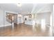Bright living room with hardwood floors, open to a modern kitchen with white cabinets at 5072 Aspen Meadow St, Raleigh, NC 27616