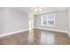 Sunlit room with hardwood floors, a modern chandelier, and large bright window at 5072 Aspen Meadow St, Raleigh, NC 27616
