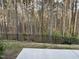 Scenic backyard view featuring a black metal fence bordering a lush green area and dense trees at 525 Rockcastle Dr, Cary, NC 27519