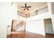 Bright, open living room features a soaring ceiling, hardwood floors, and staircase with decorative iron railing at 525 Rockcastle Dr, Cary, NC 27519