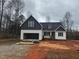 Two-story home with dark gray accent siding and an attached two-car garage on a cloudy day at 5344 Salem Woods Dr # 20, Graham, NC 27253