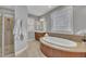 Bathroom with a large soaking tub, walk-in shower, and double sink vanity at 601 Ballad Creek Ct, Cary, NC 27519