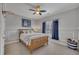 Comfortable bedroom with a ceiling fan, natural light, and wainscoting detail at 601 Ballad Creek Ct, Cary, NC 27519